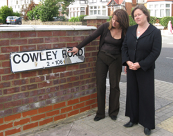 Lynne Featherstone and Helen Duffett inspecting street sign